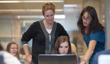 staff helping student at computer